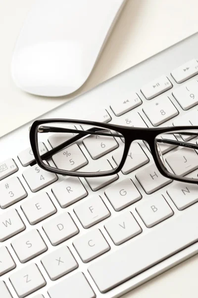 Szemüveg és billentyűzet — Stock Fotó