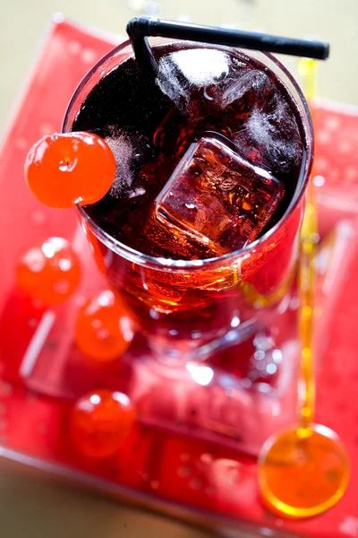 Rode drank met ijsblokjes en zwart sipper — Stockfoto