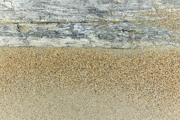 Une vieille planche de bois dans le sable — Photo