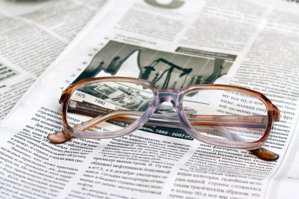 眼镜躺在一张报纸上阅读 — 图库照片