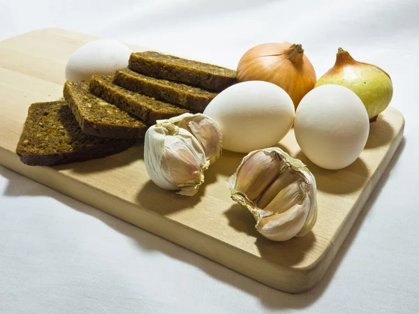 stock image Still life wiht bread, eggs, bulbs and garlic