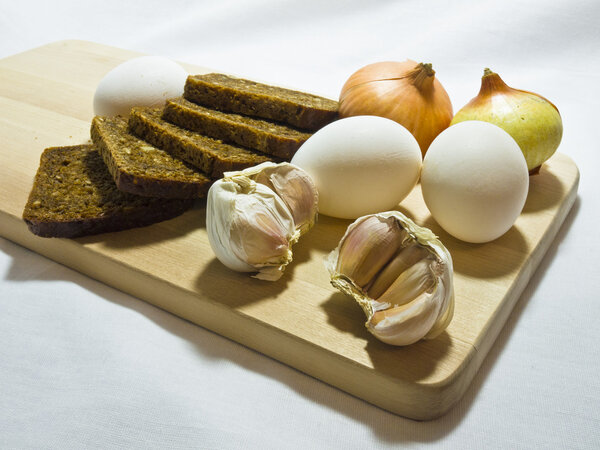 Still life wiht bread, eggs, bulbs and garlic