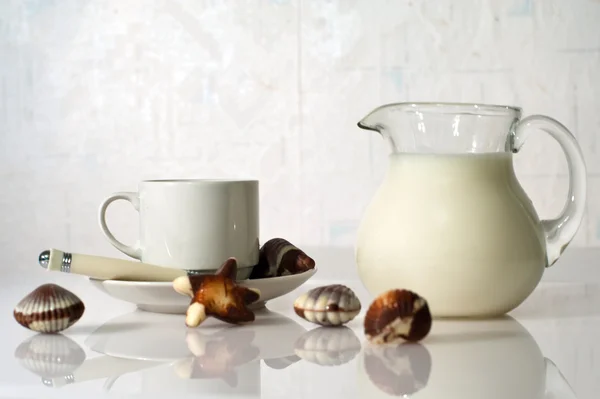 Белая чашка, молоко и сладости — стоковое фото