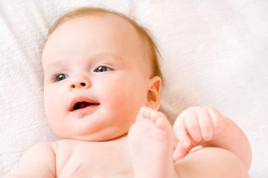 Happy charming baby is lying on the back clipart