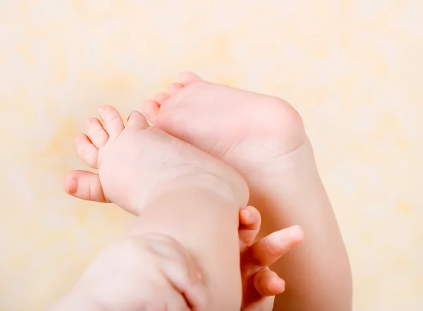 Las piernas y las manos del bebé de cerca — Foto de Stock