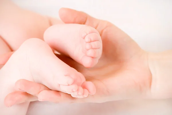 El pie del bebé en manos de la madre — Foto de Stock