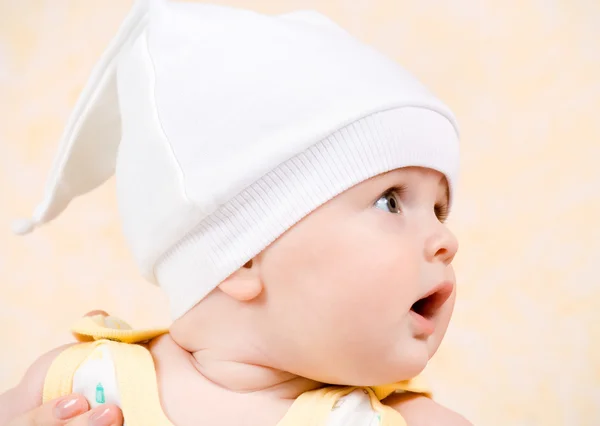 Bebê feliz em um chapéu branco olhando para cima — Fotografia de Stock