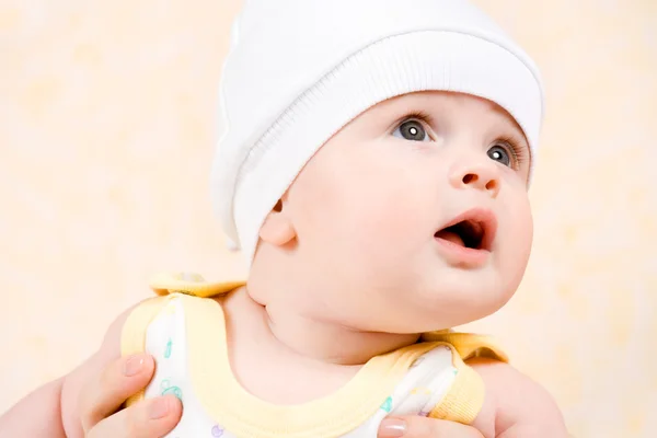 Gelukkig baby in een witte hoed opzoeken — Stockfoto