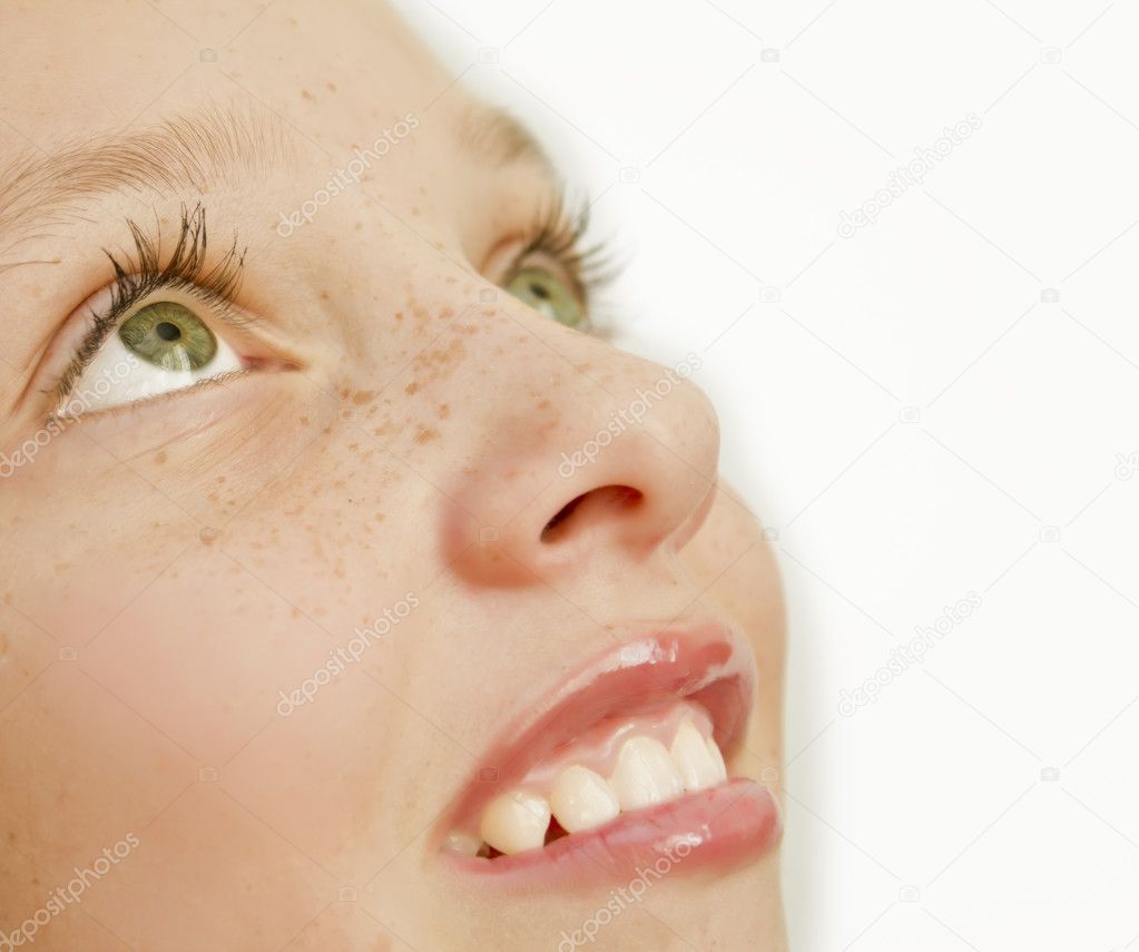 Closeup of pretty teen girl with white teeth and freckles on her face