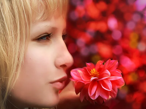 Profilé rapproché de belle femme blonde avec fleur sur fond rouge — Photo