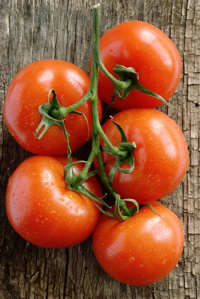 Red tomatoes on the old board — Stock Photo, Image