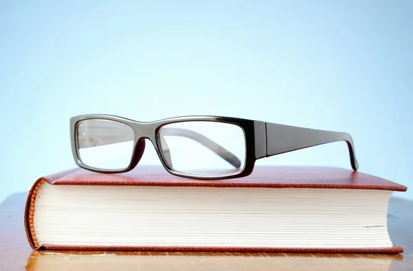 Gözlük ve bir kitap — Stok fotoğraf