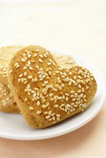 Cookies in the form of heart with sesame seeds on a plate — Stock Photo, Image