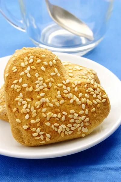 Печенье в форме сердца с кунжутом на тарелке — стоковое фото