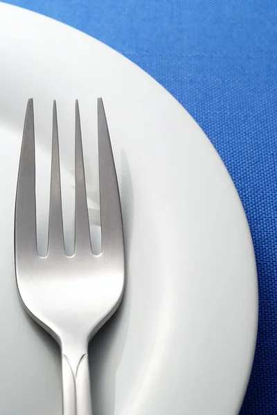 Πιρούνι και ένα πιάτο σε ένα μπλε χαρτοπετσέτα — Φωτογραφία Αρχείου