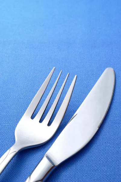 Πηρούνι και μαχαίρι σε μια μπλε χαρτοπετσέτα — Φωτογραφία Αρχείου