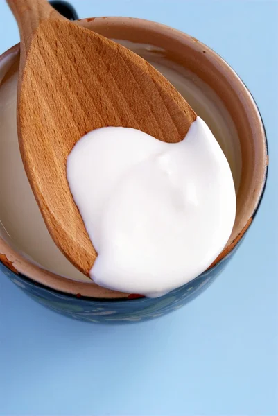 Crema in una tazza e un cucchiaio di legno — Foto Stock