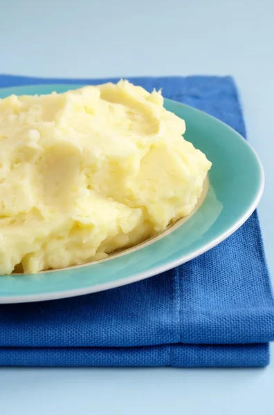 Tłuczone ziemniaki w misce i niebieski tkaniny na stole — Zdjęcie stockowe
