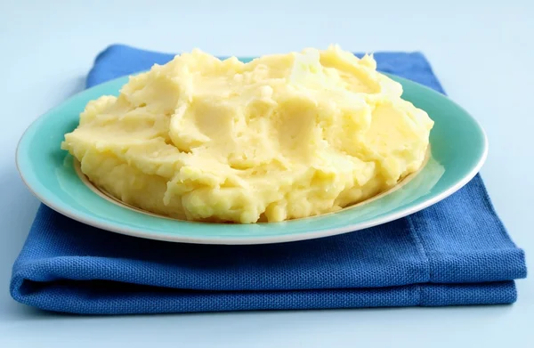 Purê de batatas em uma tigela e um pano azul na mesa — Fotografia de Stock