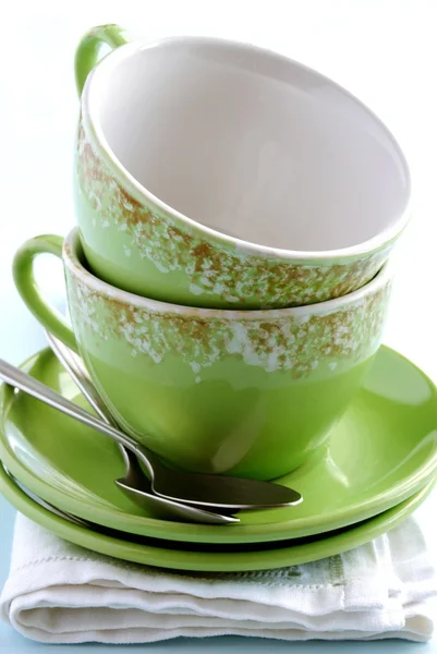 绿色杯、 碟和一张餐巾纸上的勺子 — 图库照片