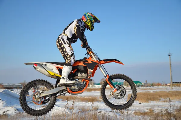 A bike motocross Rider repül át hill, havas autópályán — Stock Fotó