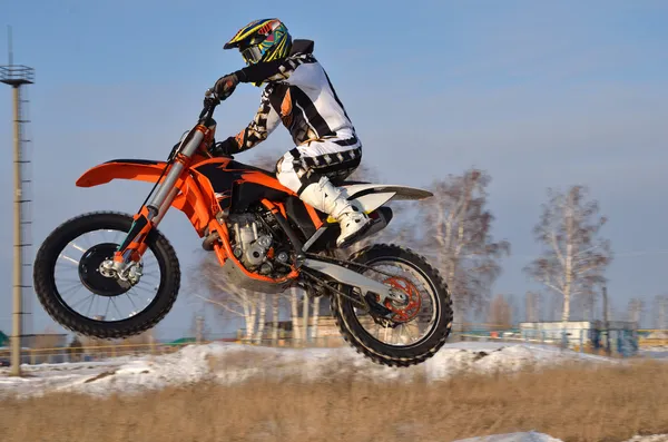 Motocross, motorcycle driver flies over hill out of snow — Stock Photo, Image