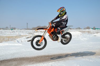 Motocross sürücü kardan tepe üzerinde uçar