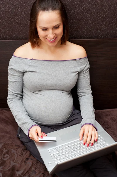 Беременная женщина делает покупки через интернет на дому — стоковое фото