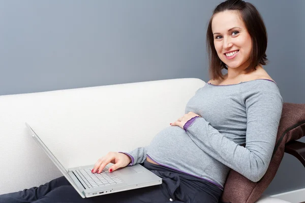 Έγκυος γυναίκα με φορητό υπολογιστή στο σπίτι — Φωτογραφία Αρχείου