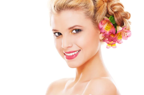 Студийное фото молодой улыбчивой женщины с цветами в волосах — стоковое фото