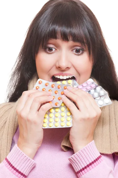 Студийный снимок женщины, которая ест таблетки — стоковое фото