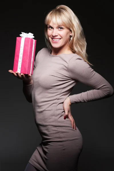 Young woman with present over dark background — Stock Photo, Image