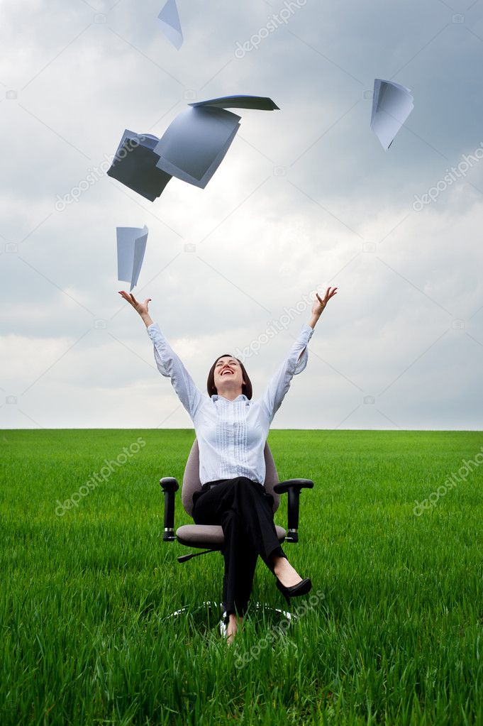 Businesswoman throwing away documents at the field