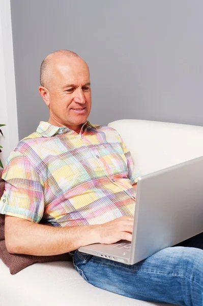 Homme âgé avec ordinateur portable à la maison — Photo