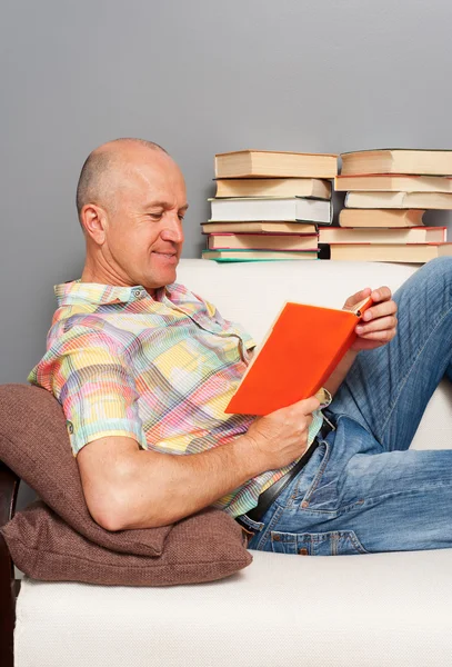 Homem sênior lendo o livro em casa — Fotografia de Stock