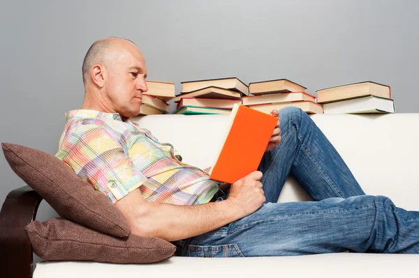 Мужчина читает книгу дома — стоковое фото