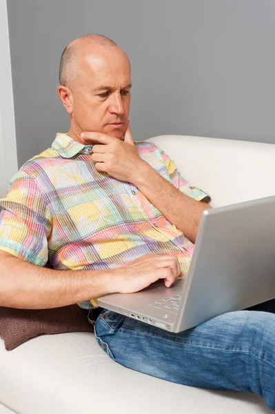 Senior homme avec ordinateur portable à la maison — Photo