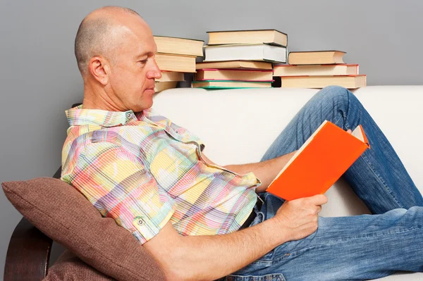 Расслабленный пожилой человек, читающий книгу — стоковое фото