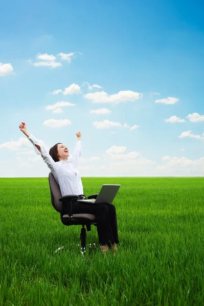 Happy young woman with laptop on the meadow — Stock Photo, Image