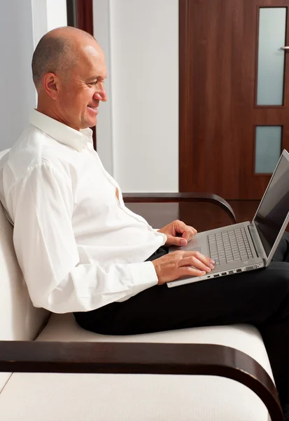 Mannen i skjorta med laptop hemma — Stockfoto
