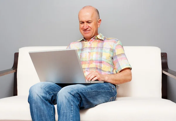 Smiley senior man använder laptop — Stockfoto