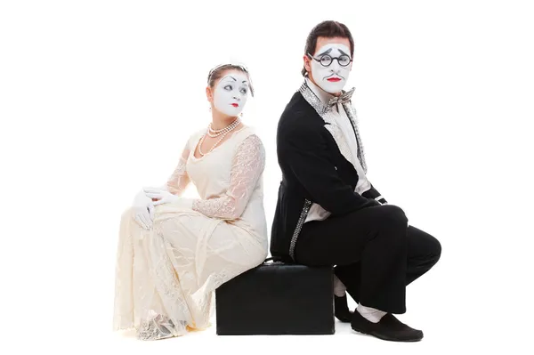 Studio shot van twee mimespelers zittend op koffer — Stockfoto