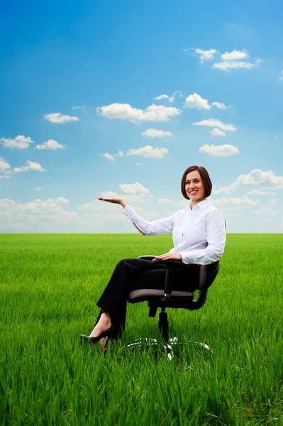 Businesswoman holding something on her hand at the meadow — Stock Photo, Image