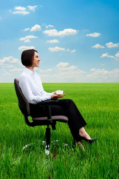 Businesswoman relaxing at the meadow with cup of coffee — Stock Photo, Image