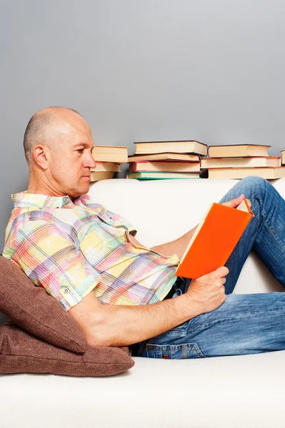 Homem em casa lendo o livro — Fotografia de Stock