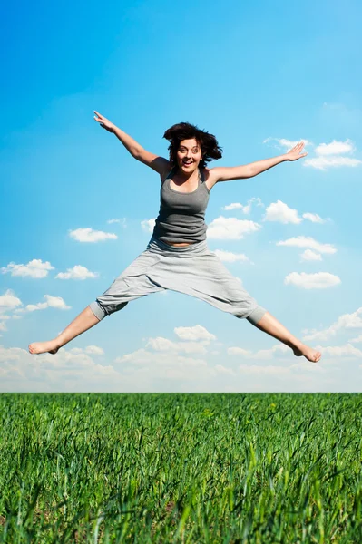 Gelukkige vrouw springen op het veld — Stockfoto