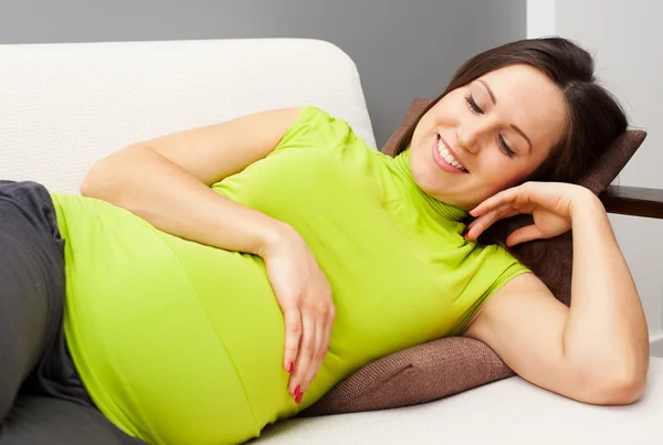 Έγκυος γυναίκα αναπαύεται στον καναπέ — Φωτογραφία Αρχείου