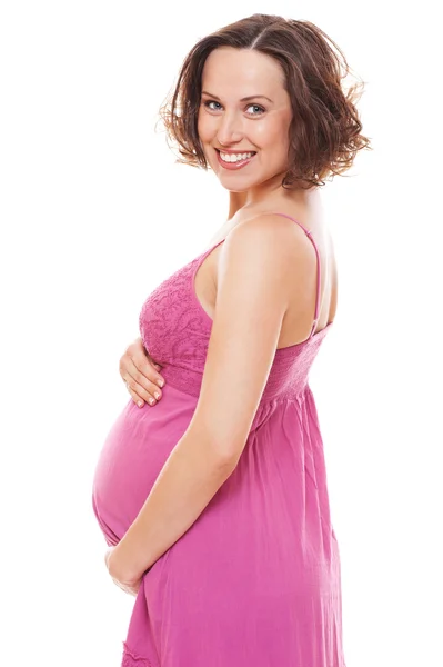 Glückliche schwangere Frau in rosa Kleid — Stockfoto