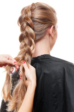 Hairdresser doing up one's hair in a plait clipart