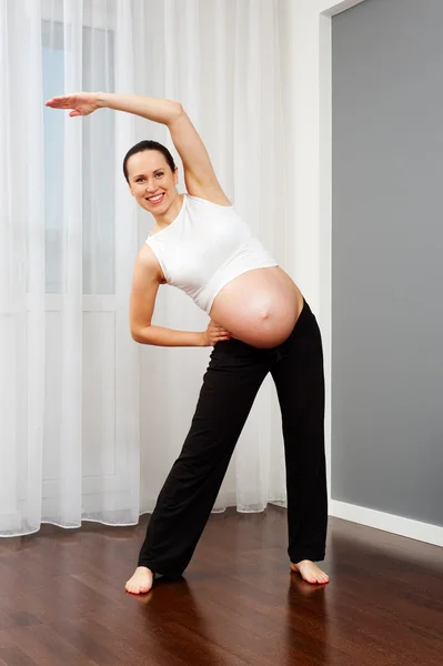 Pregnant woman doing gymnastic at home — Stock Photo, Image